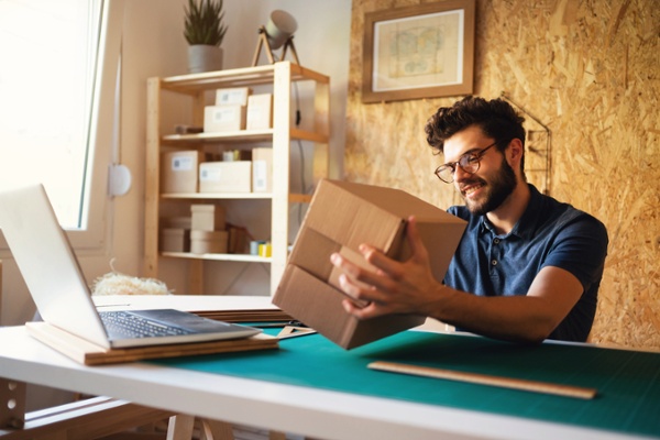 Business owner comparing Advanced Shipping Manager vs. Real-Time Shipping Quotes for eco-friendly packaging