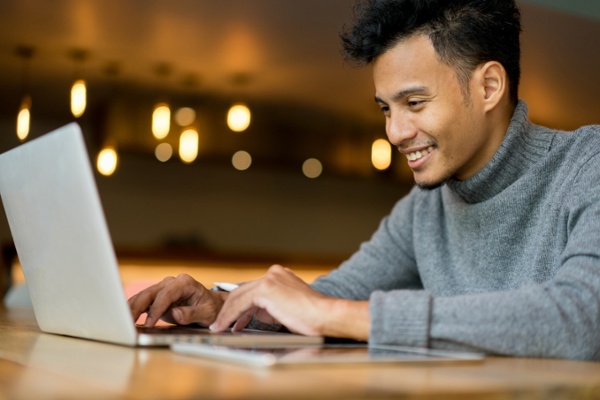 Business owner on his laptop deciding whether to use Service Hub or HappyFox