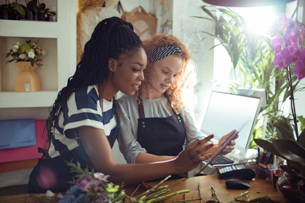 Co-owners of a flower shop organizing their Shopify inventory management processes