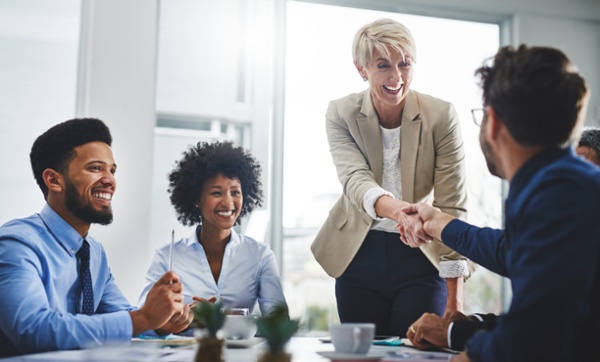 Executives shaking hands to represent Stamps.com acquisitions