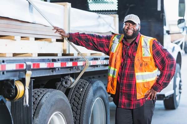 LTL truck driver next to his loaded truck