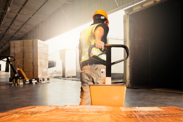 Man hauling a pallet full of boxed freight