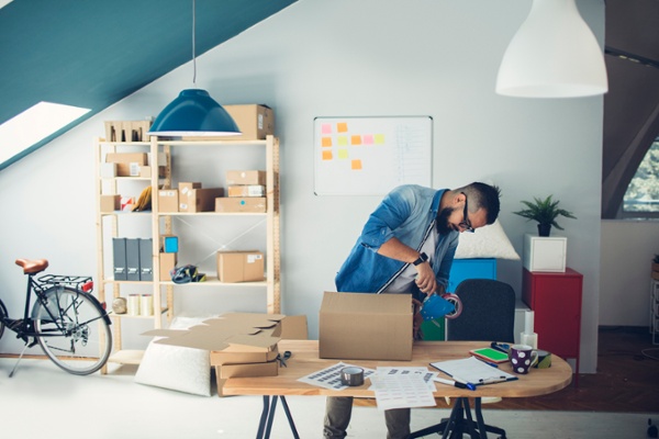 Man packaging shipments in his office-1