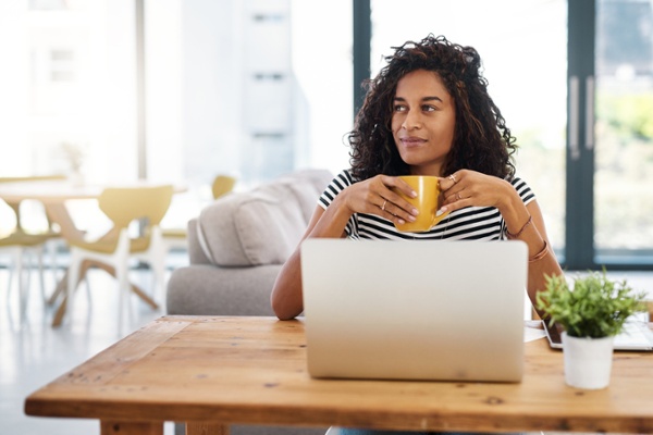 Peaceful customer service employee thinking in front of her laptop