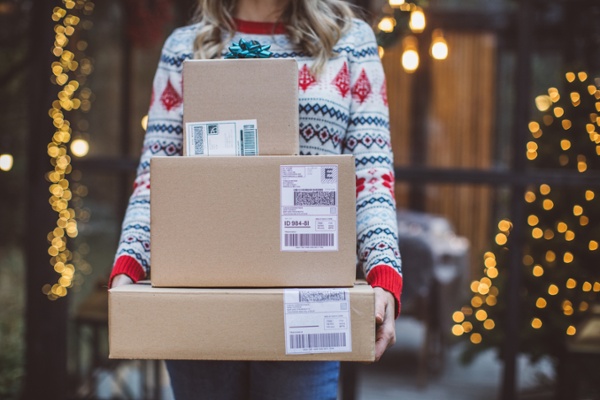 Shopper in a holiday sweater receiving their packages on time