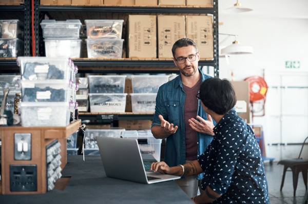 Two business partners discussing FreightDesk Online vs. Shopify Shipping at work